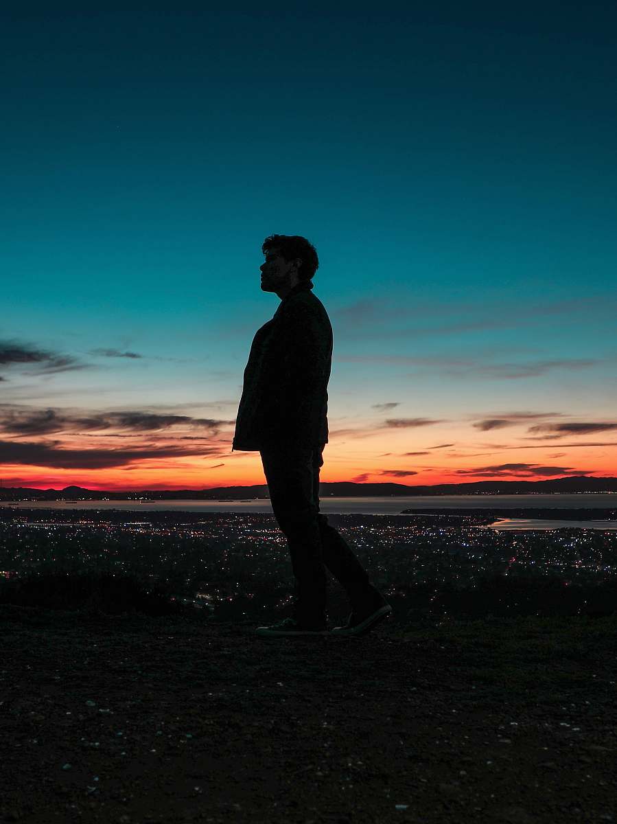 person silhouette on man standing on seashore people