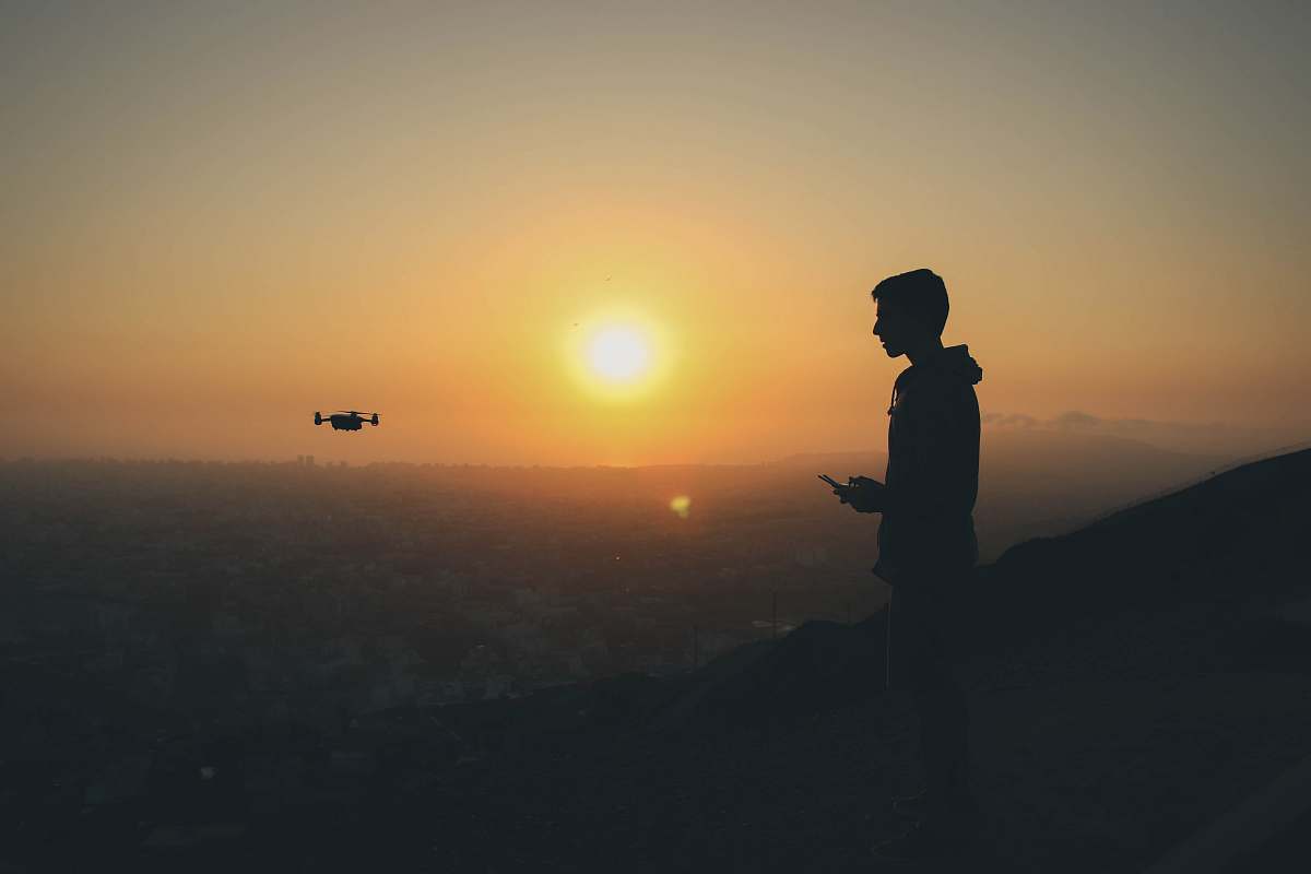 person silhouette photo of man holding drone remote people