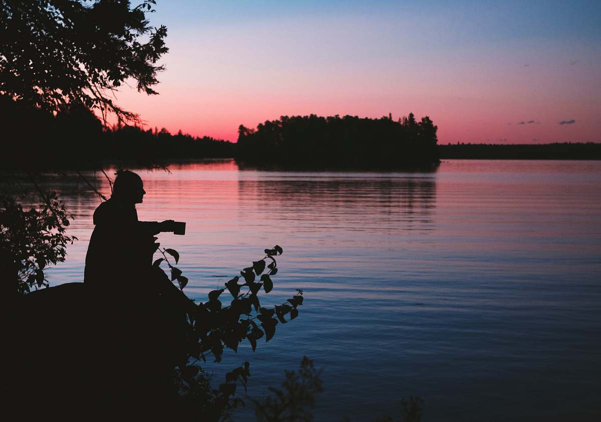 people silhouette photo of man sitting beside body of water person