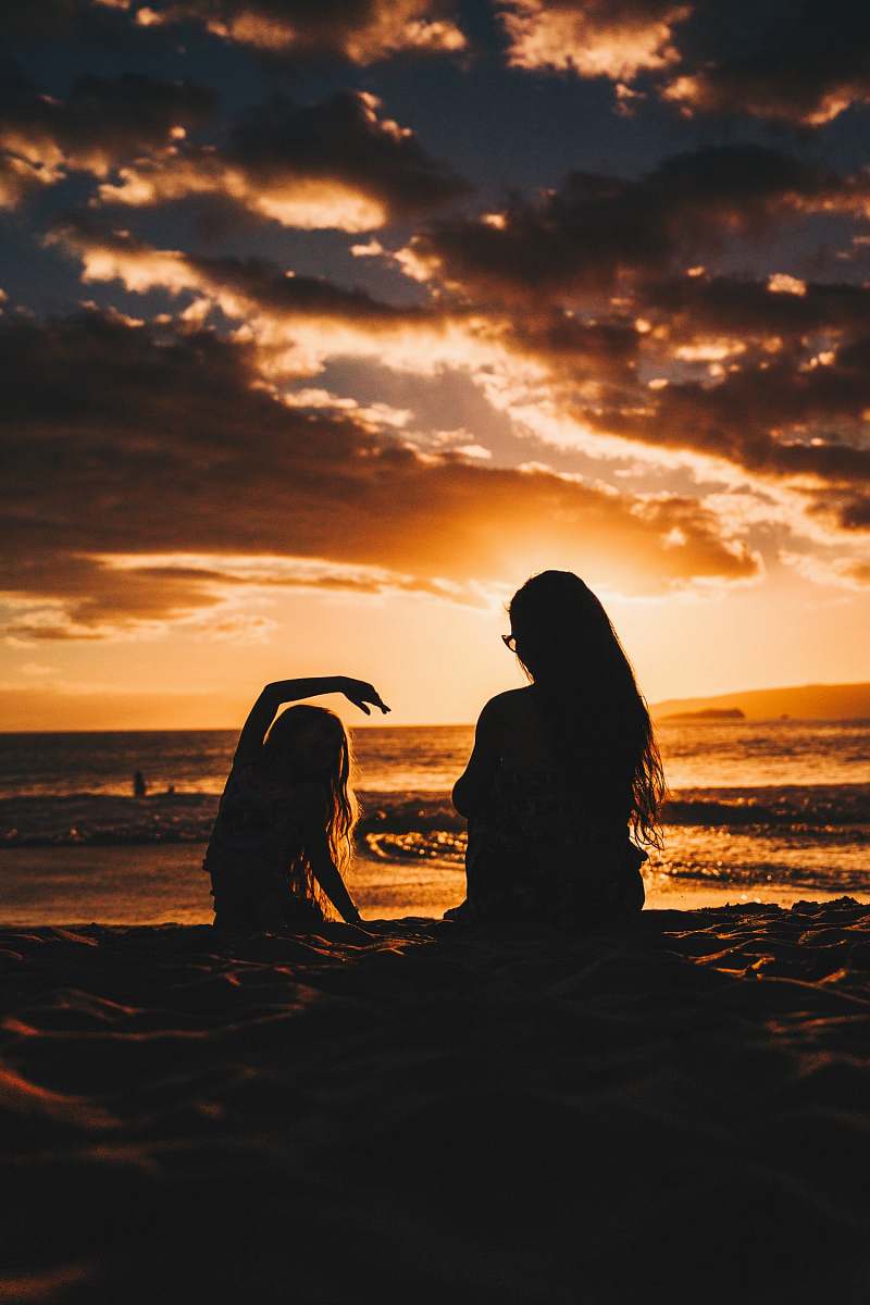 person silhouette photo of woman and girl on shoreline people