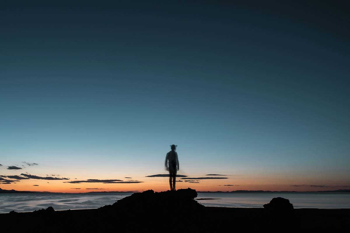 person sillhouette of a man facing the beach standing
