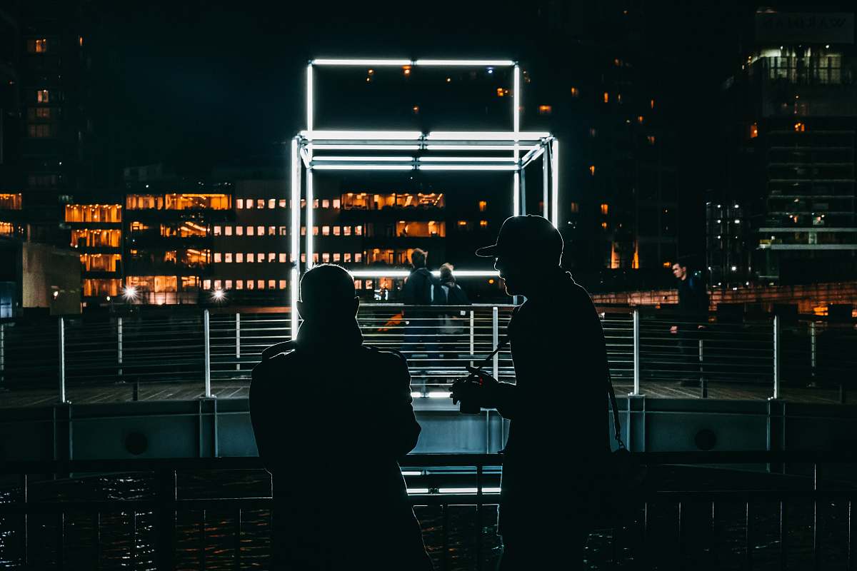 person wo men talking in front of LED light frame people