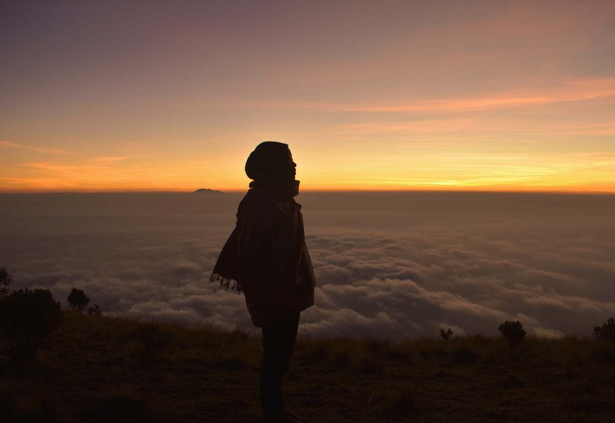 person woman looking sideways standing near cliff people