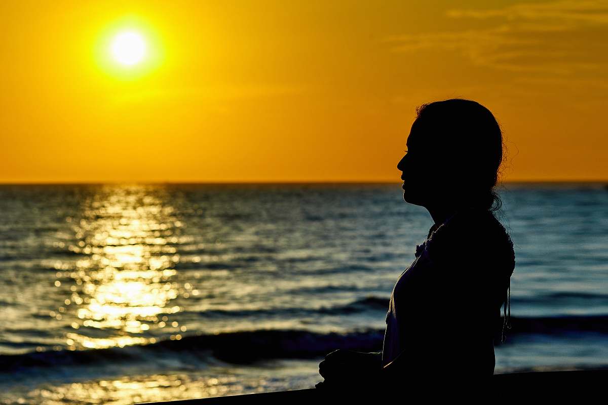 person woman standing infront of beach during sunset people