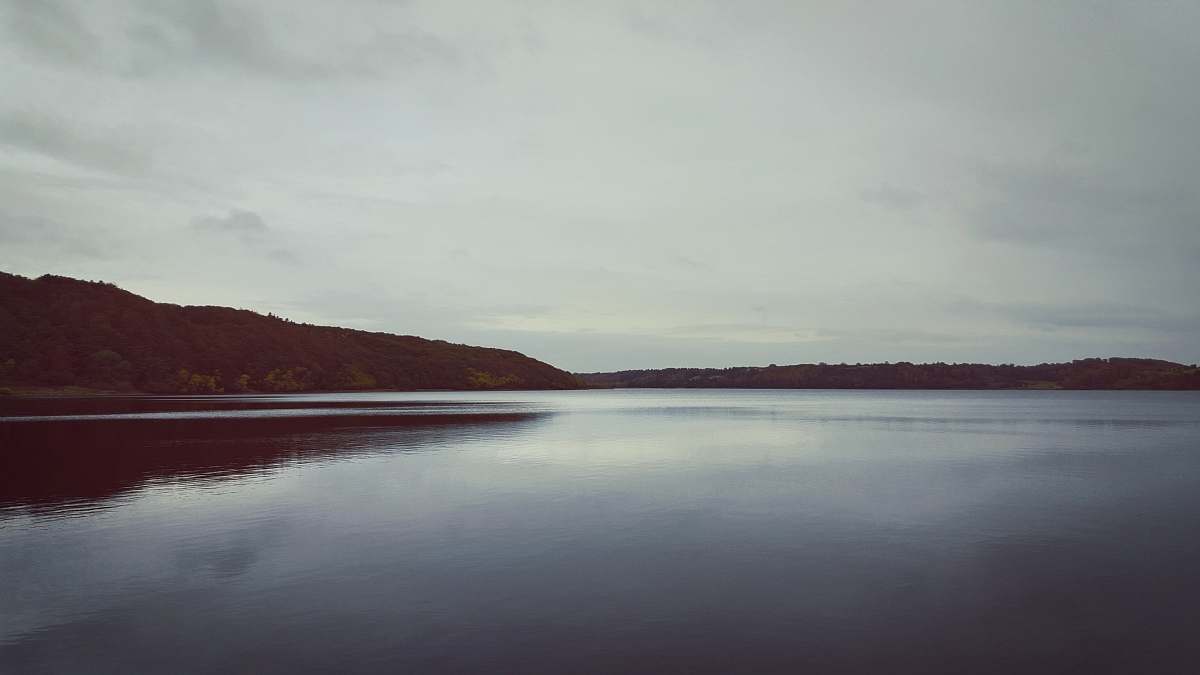 grey body of water near mountain during daytime water