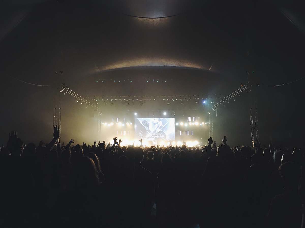 crowd crowd standing near stage with band at night concert