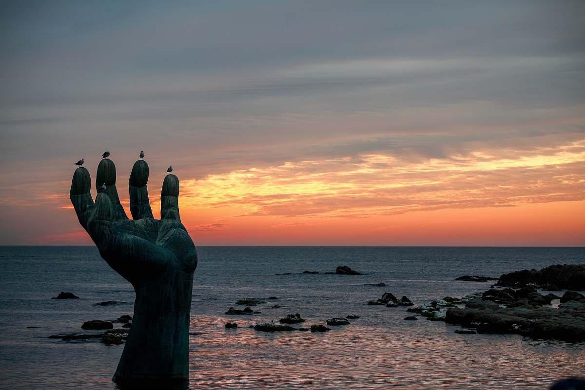 outdoors hand statue in seashore silhouette