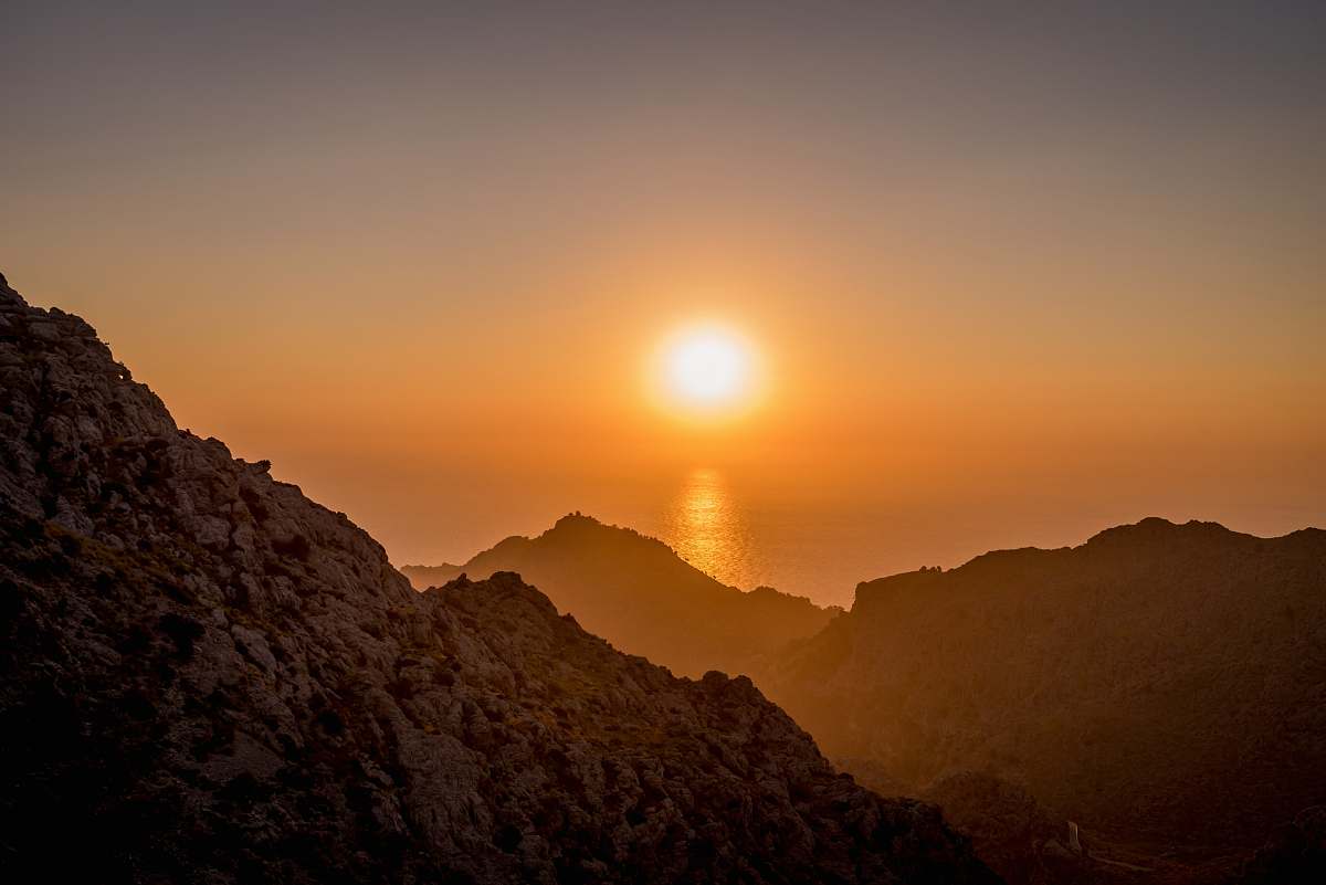 sunrise landscape photo of brown mountains near body of water mountains