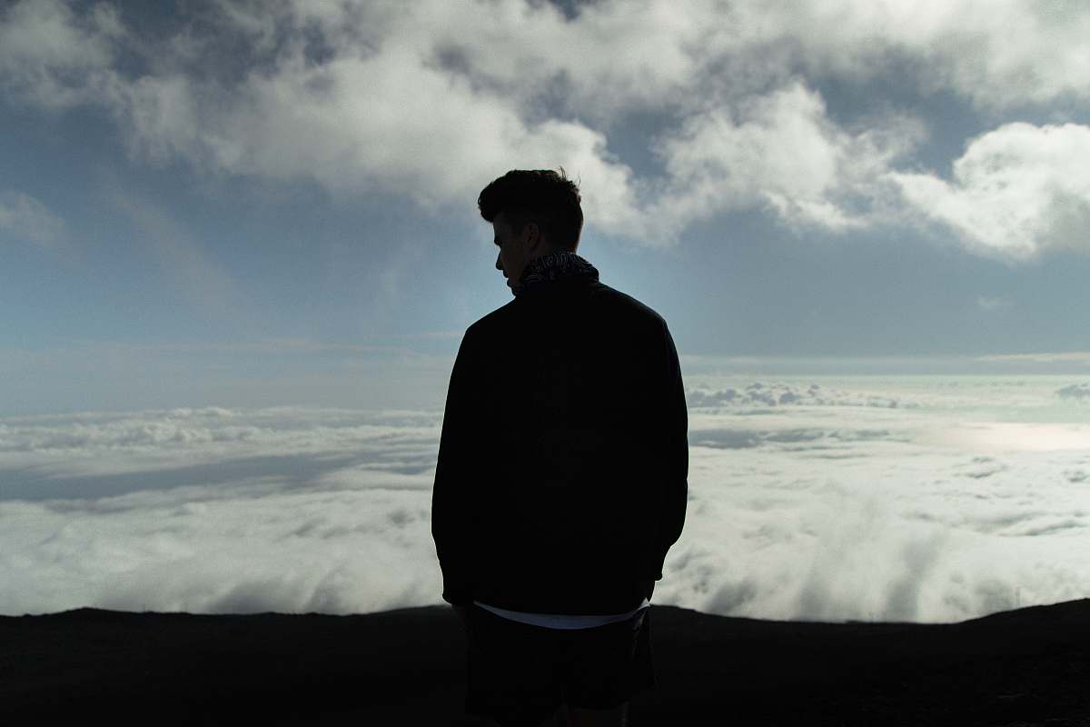 human man standing with sea of clouds in background person
