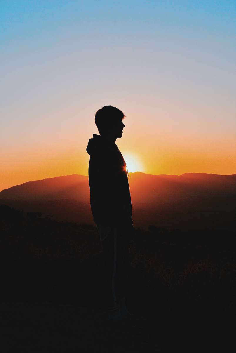 outdoors man wearing hoodie during golden hour sunset