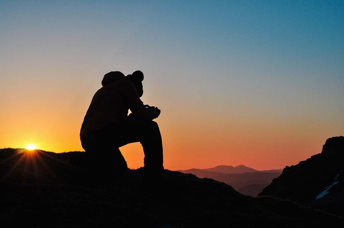 human person standing on top of mountain outdoors