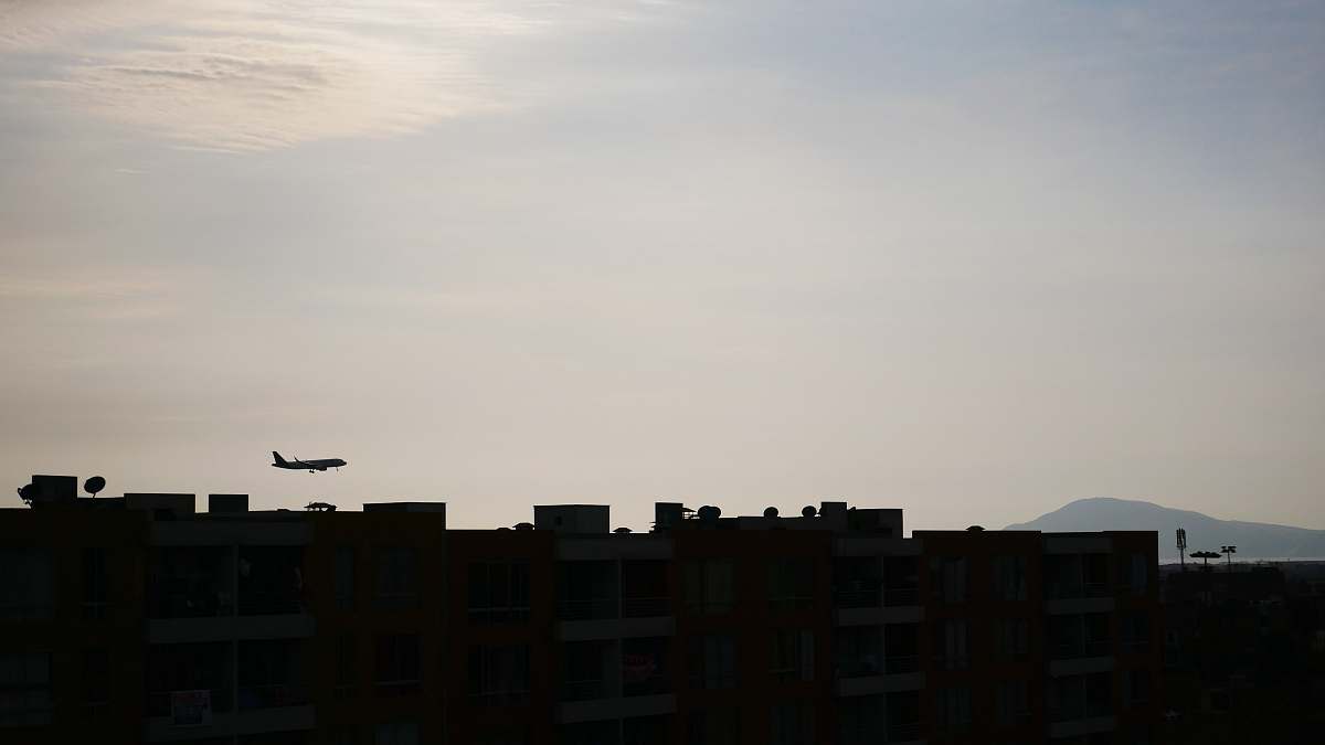 outdoors silhouette of buildings and airplane under white sky silhouette