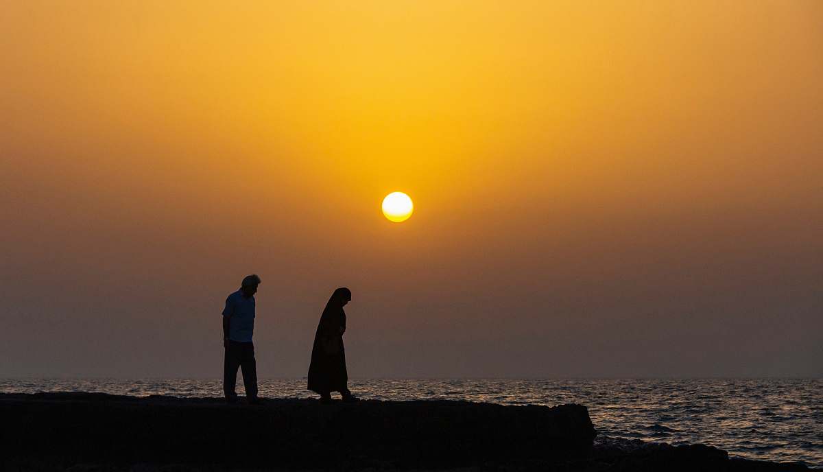 person silhouette of man and woman by the body of water at sunset human