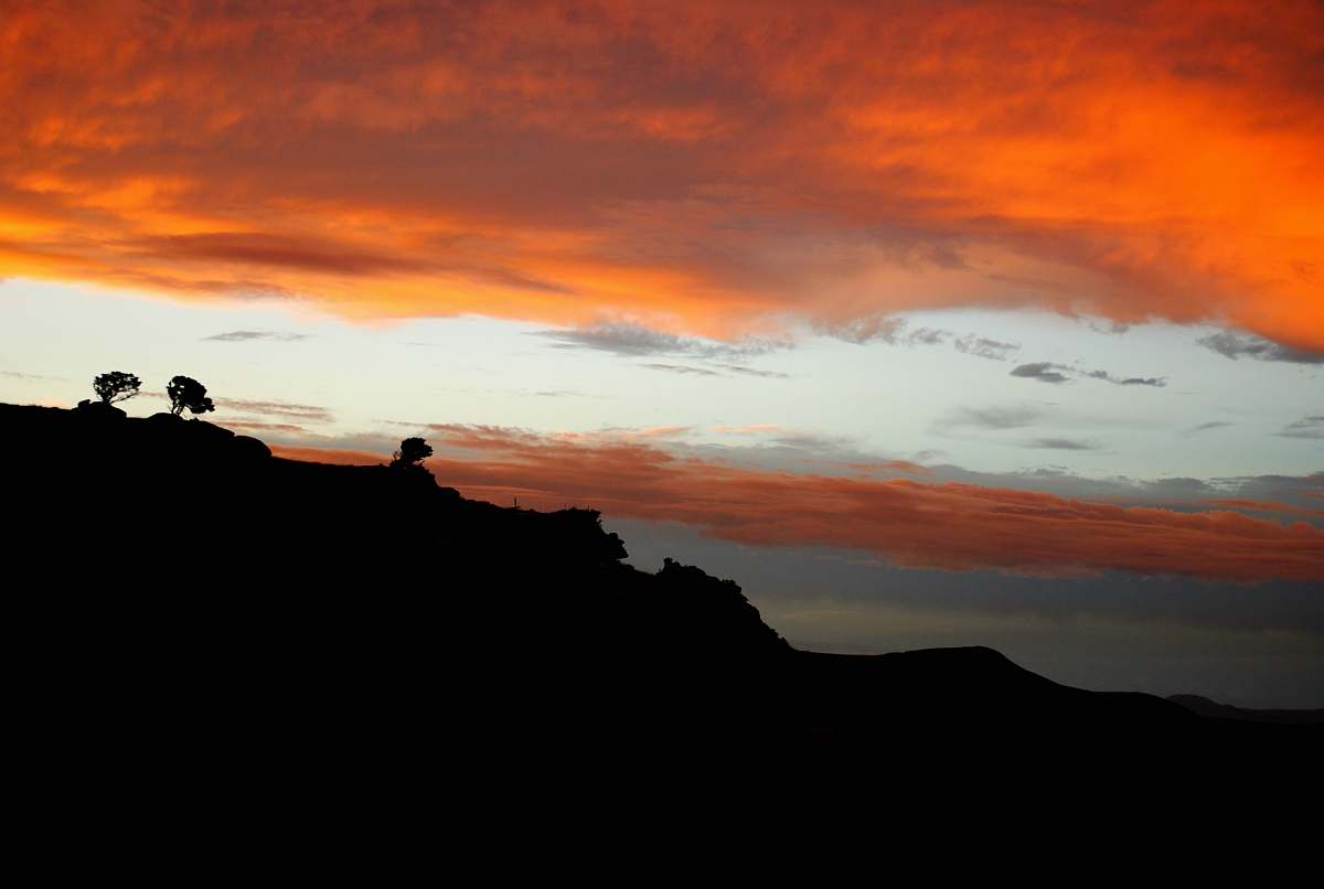 sky silhouette of mountain and tree during golden hour outdoors