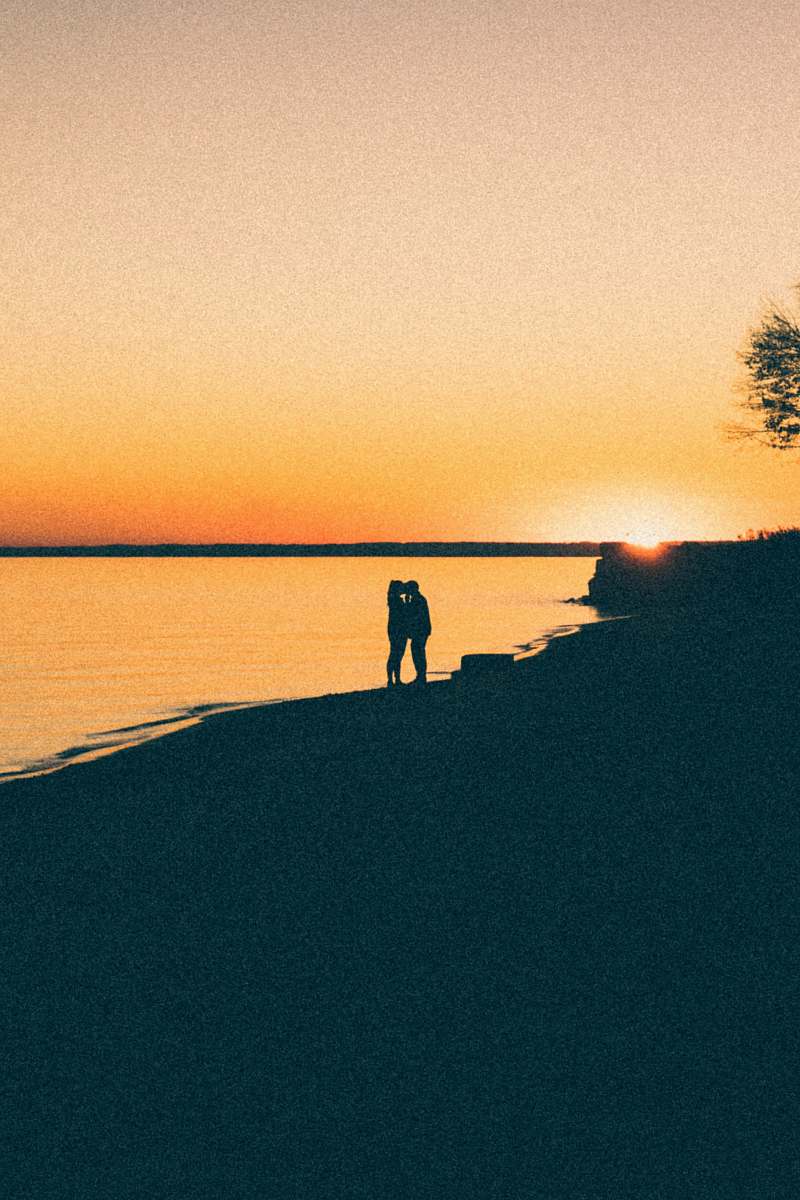 outdoors silhouette photo of two person kissing each other dawn