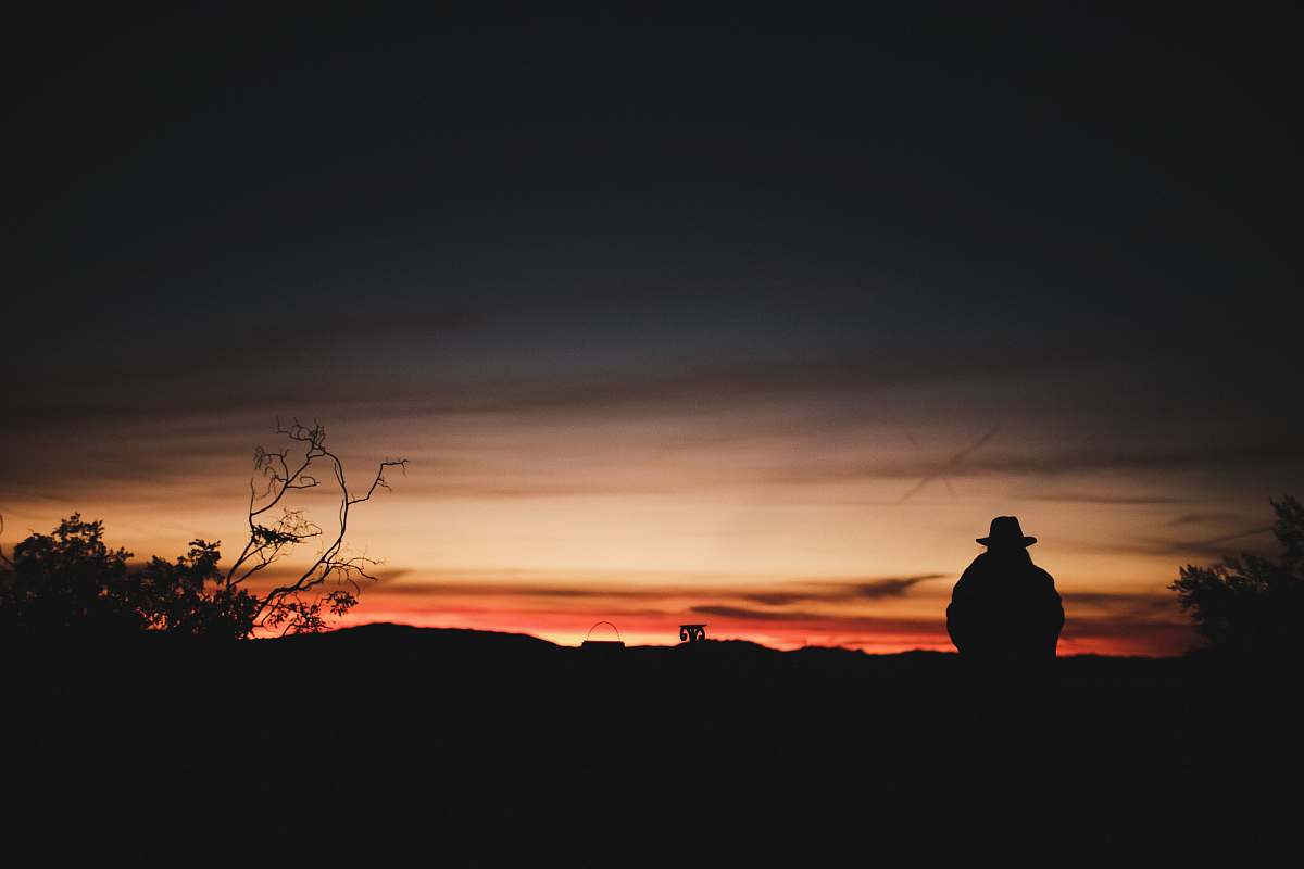 silhouette silhouette photography of person sitting on mountain outdoors