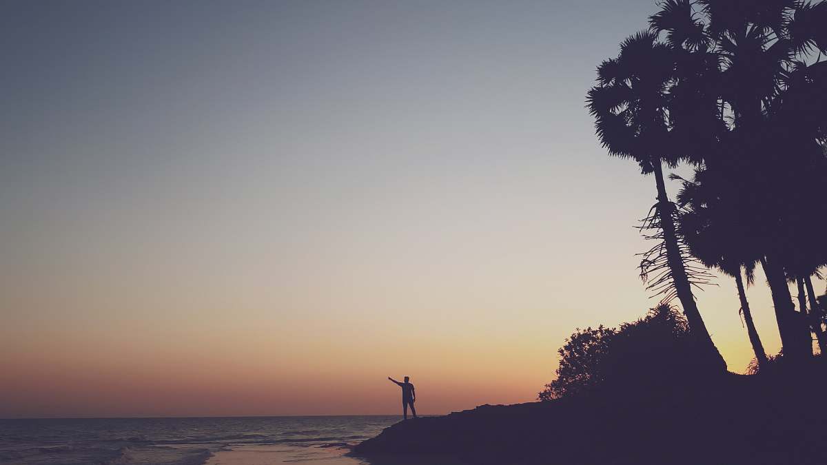 outdoors silhouette photography of person standing on shore silhouette