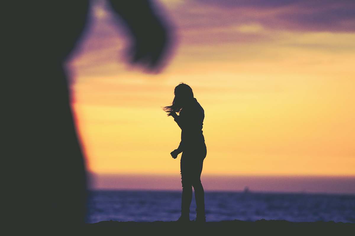 people silhouette photography of woman standing at beach human