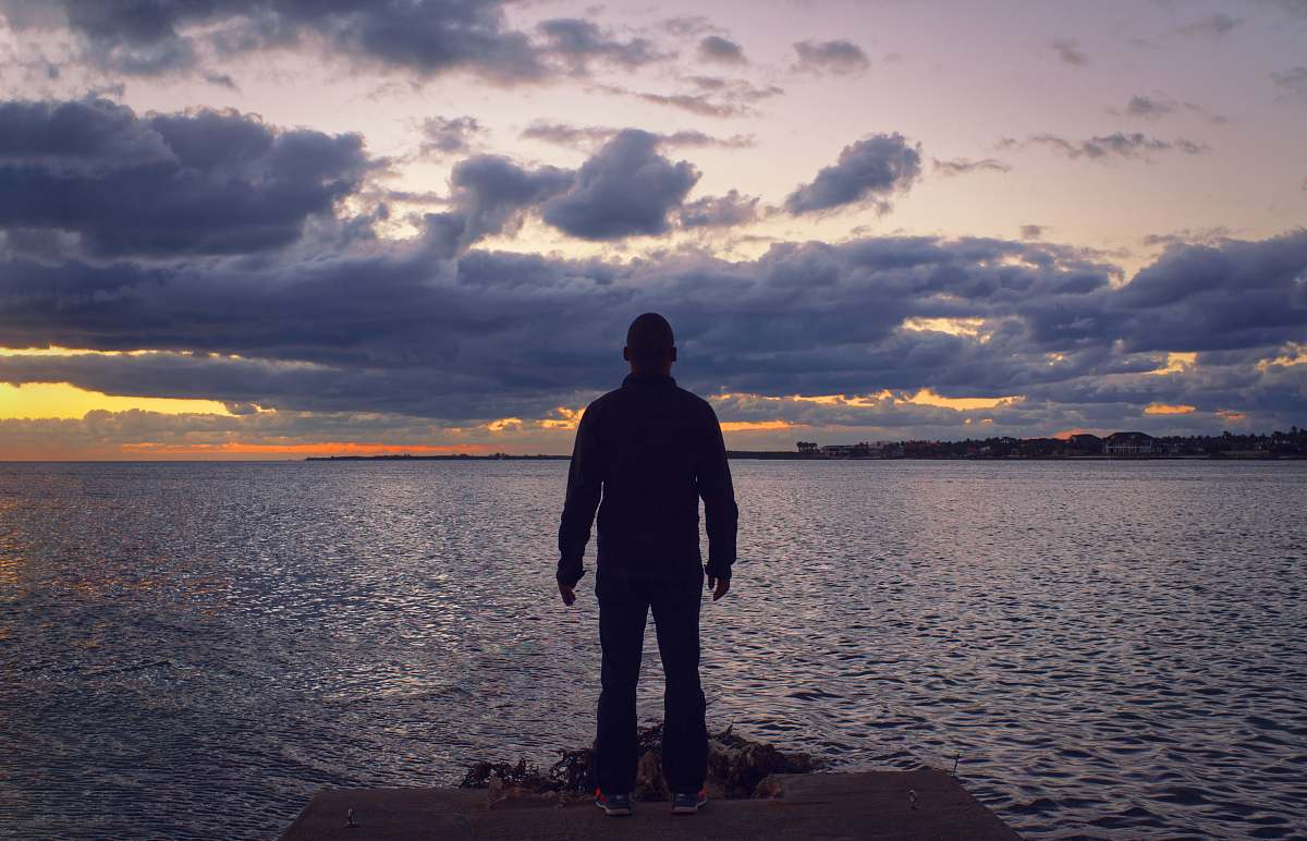 person man standing in front of sea human