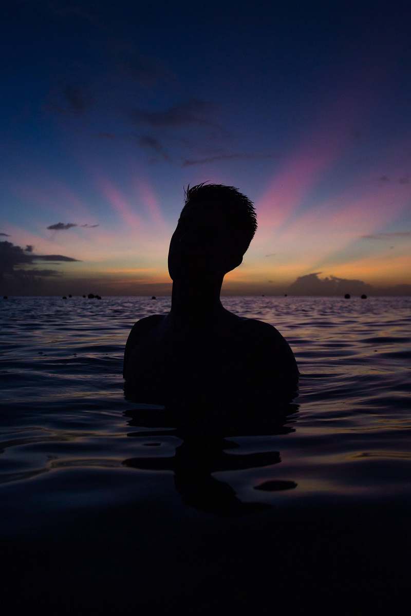 sunset person in body of water during golden hour water