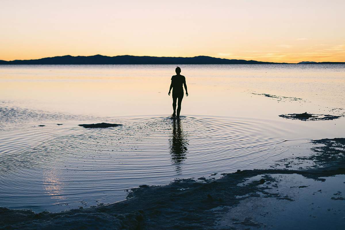 silhouette silhouette of person standing on body of water great salt lake
