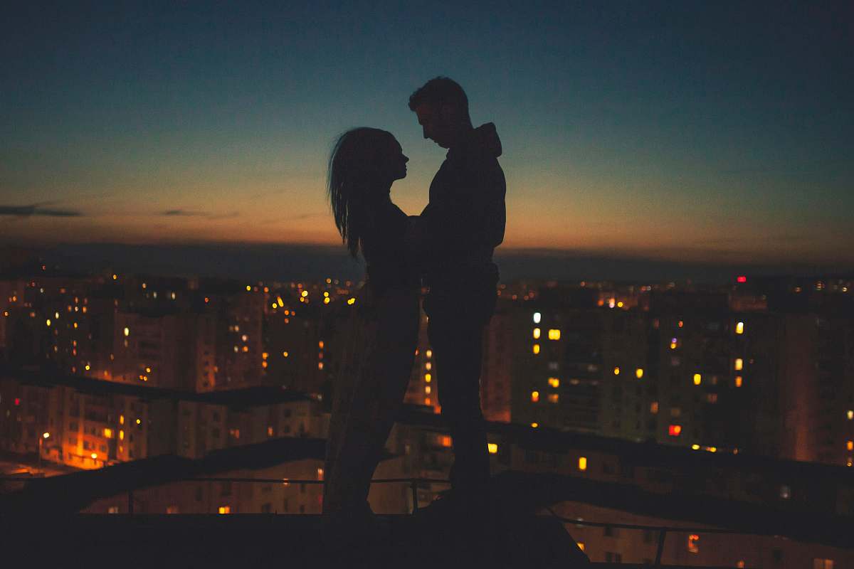 person silhouette of man and woman standing on roof building human