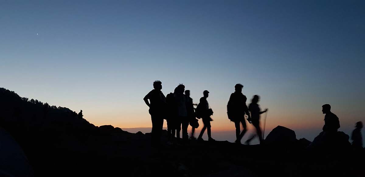 person silhouette on people standing on mountain during blue hour human