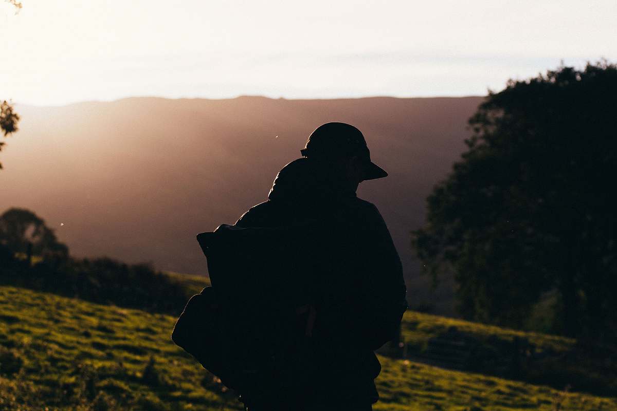 person silhouette photo of person carrying backpack during daytime human
