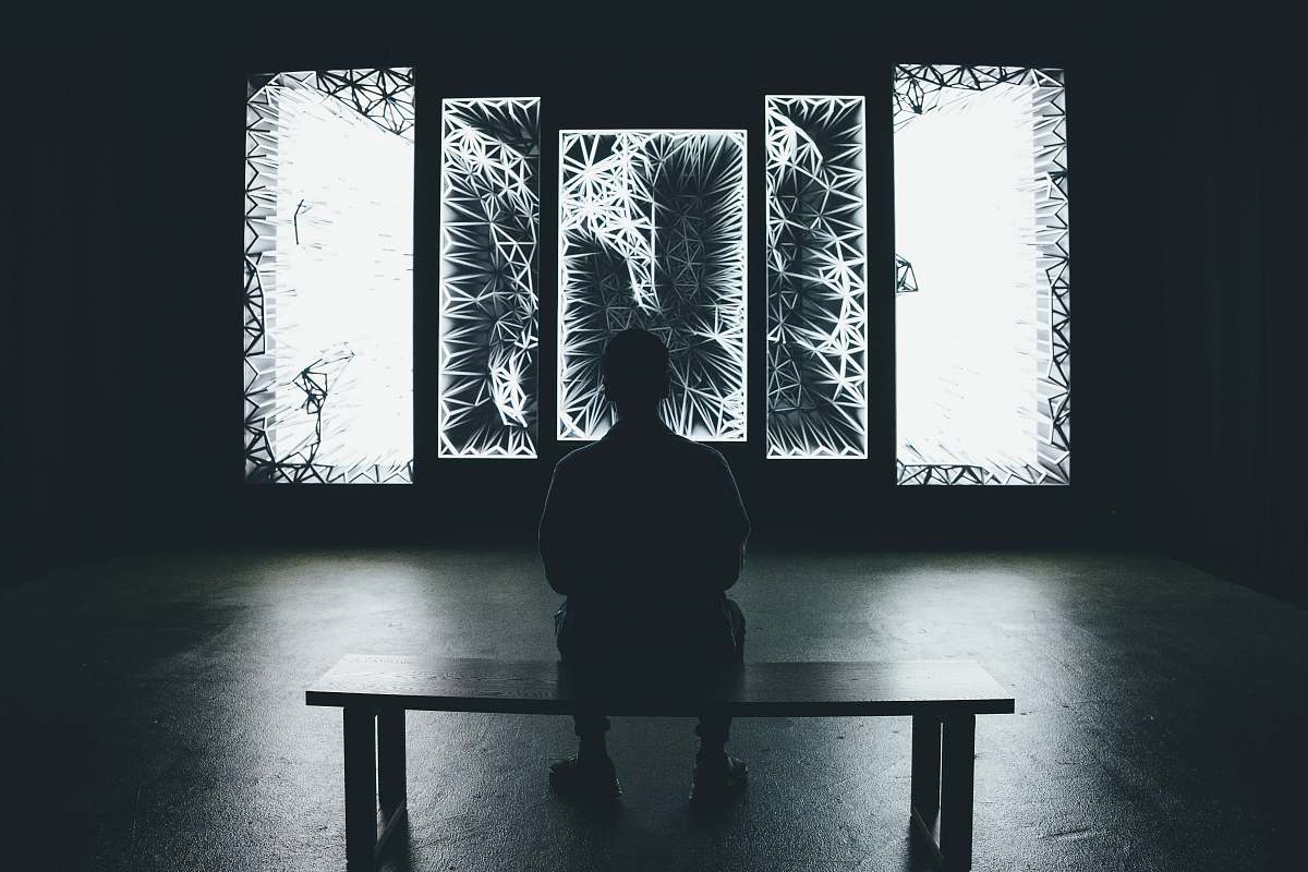 human grayscale photography of man sitting on bench bench