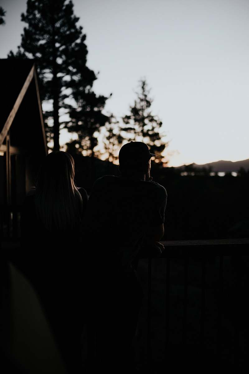 silhouette man and woman sitting beside handrail human