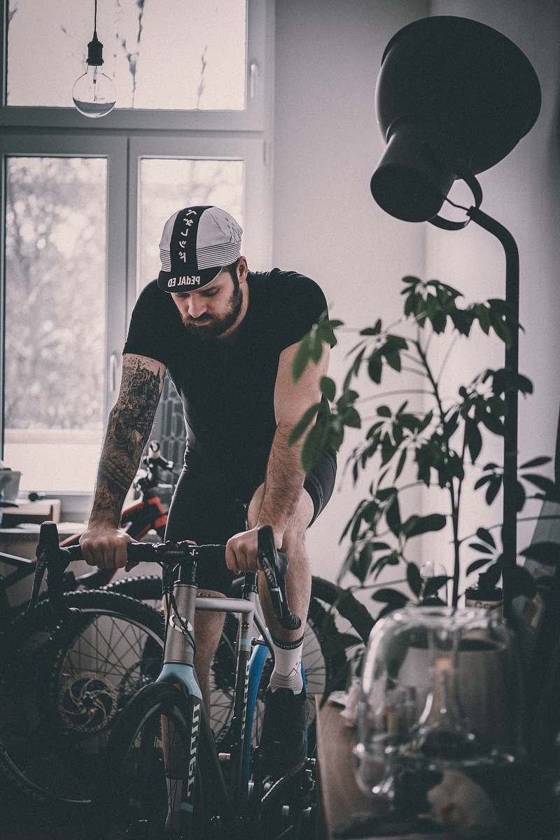 bicycle man riding on gray rigid bicycle near window bike