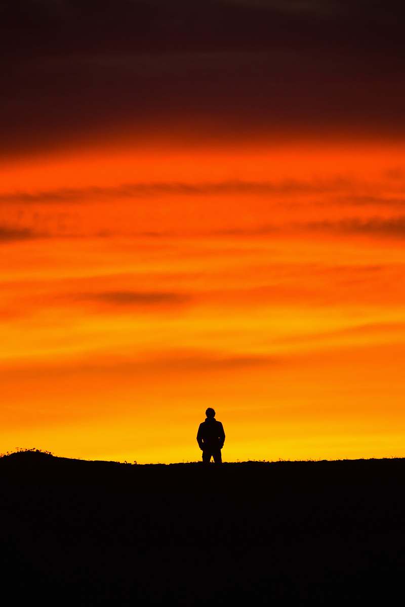 silhouette man standing at peak at golden hour nature