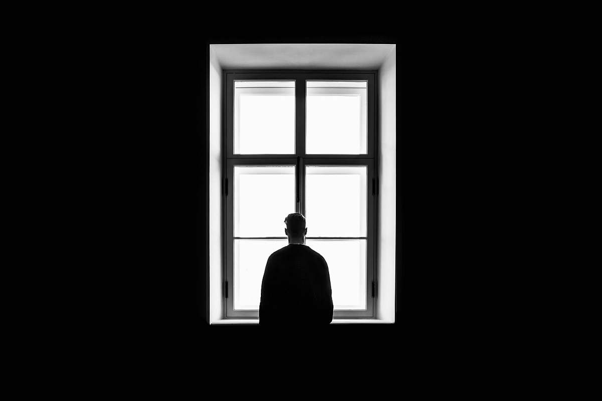 black-and-white man standing in front of the window window