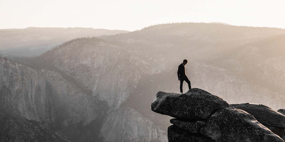 rock man standing on top of mountain during daytime landscape