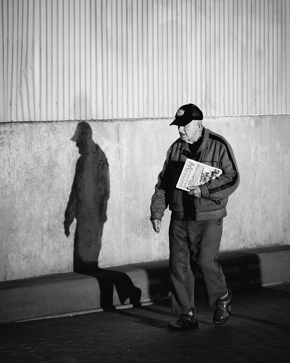 black-and-white man walking on the sidewalk people