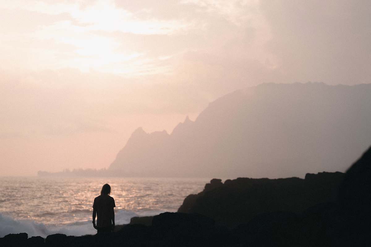 human person standing in seashore during golden hour nature