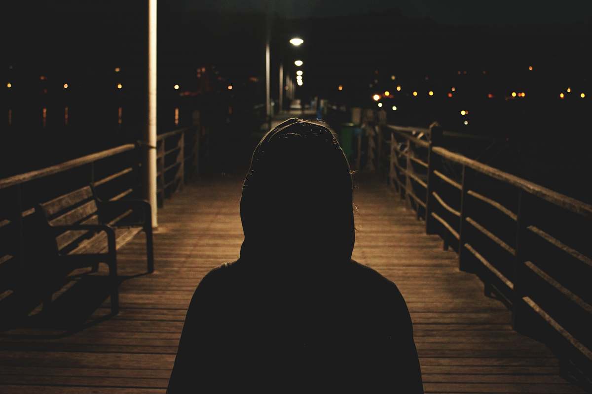 human person wearing hooded jacket walking in bridge people