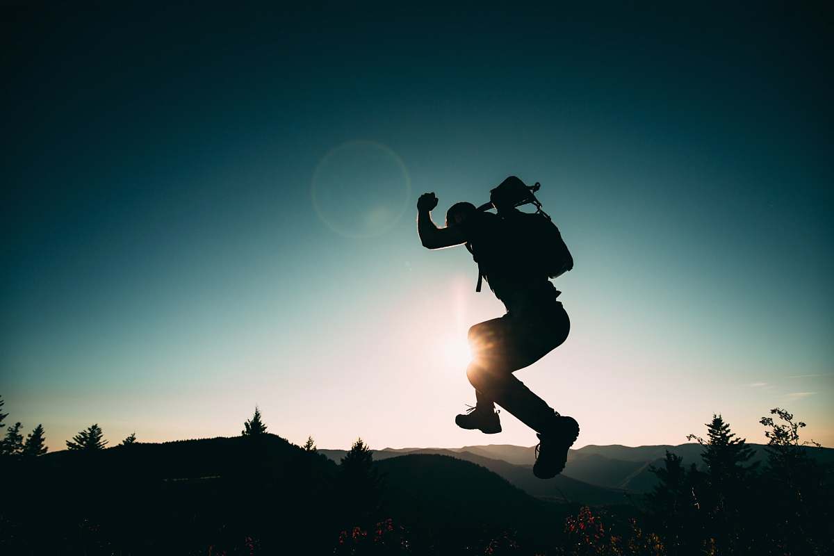 human silhouette of jumping person on hill people