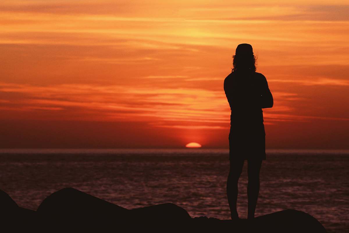 human silhouette of man standing near body of water people