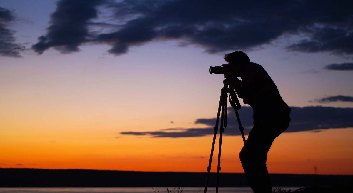 photographer silhouette of man taking picture tripod