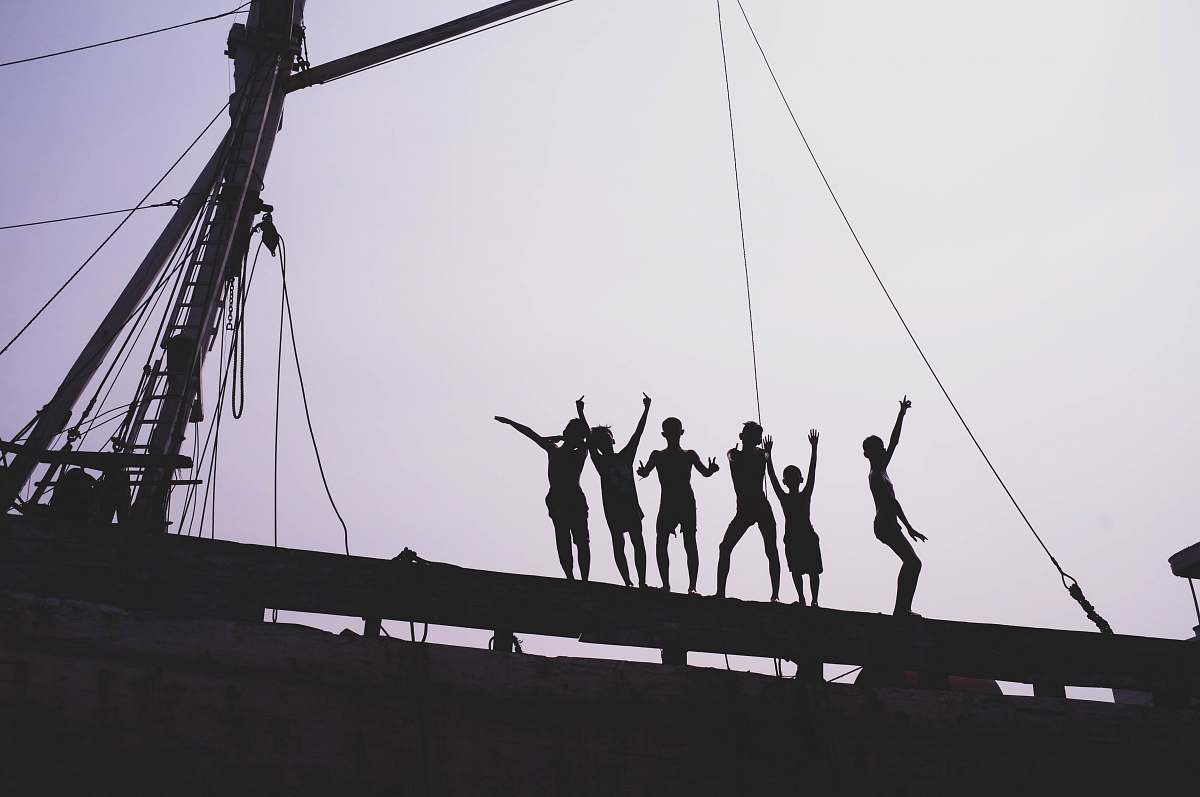 human silhouette of people standing near post sunda kelapa