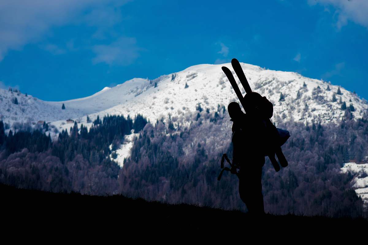 human silhouette of person climbing mountain during daytime people