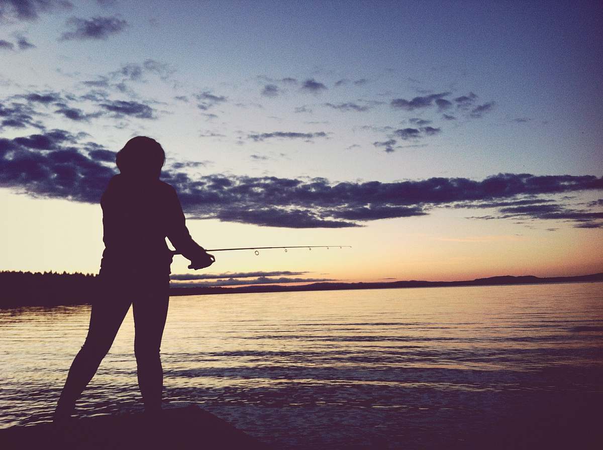 silhouette silhouette of person holding fishing rod taken at sunset human