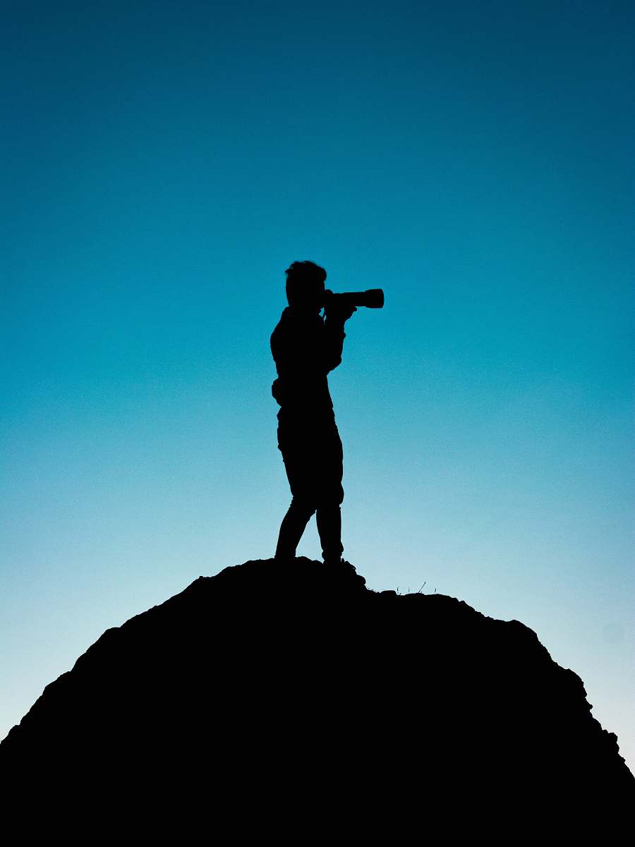 human silhouette of person holding telescope graphic standing