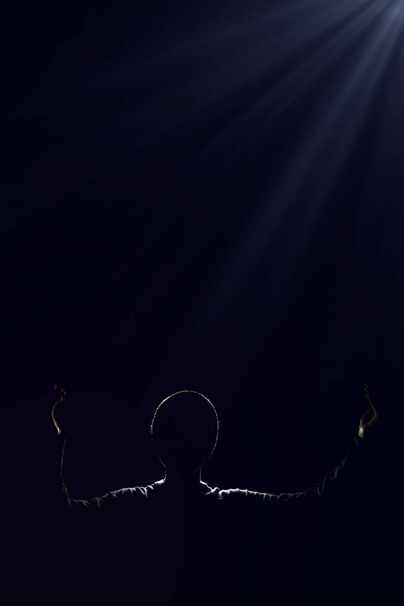 black silhouette of person raising two hands dark