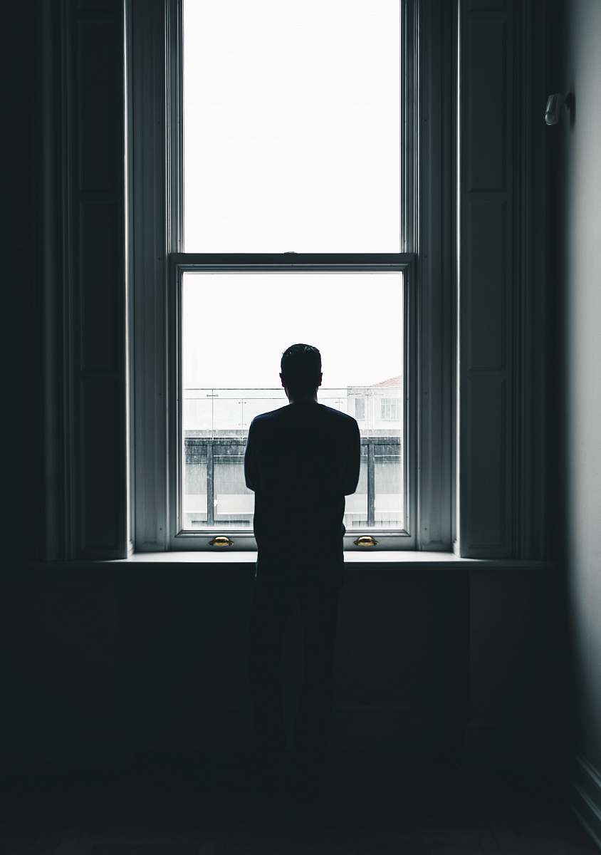 human silhouette of person standing in front of window at daytime people