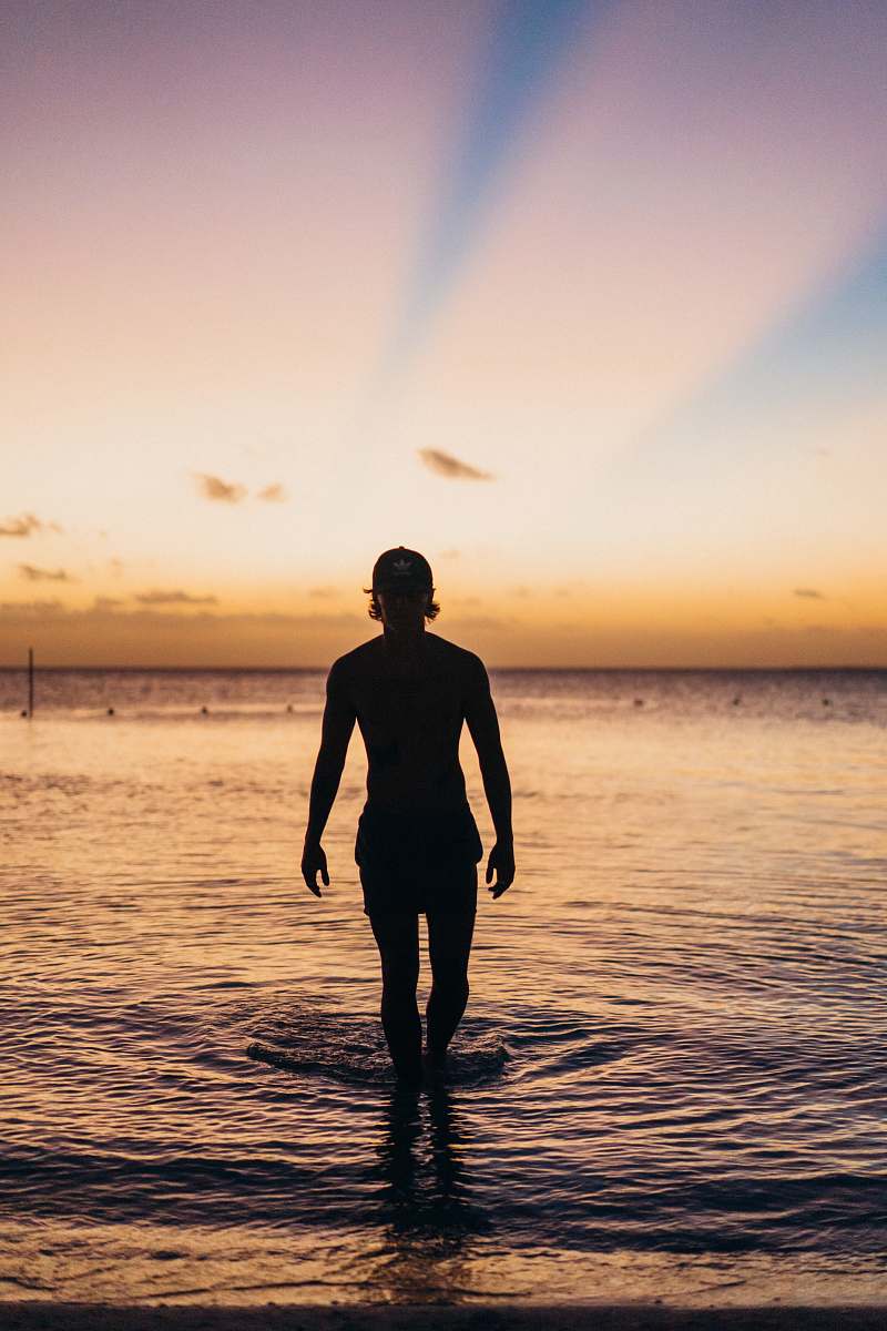 human silhouette of person standing on beach line standing