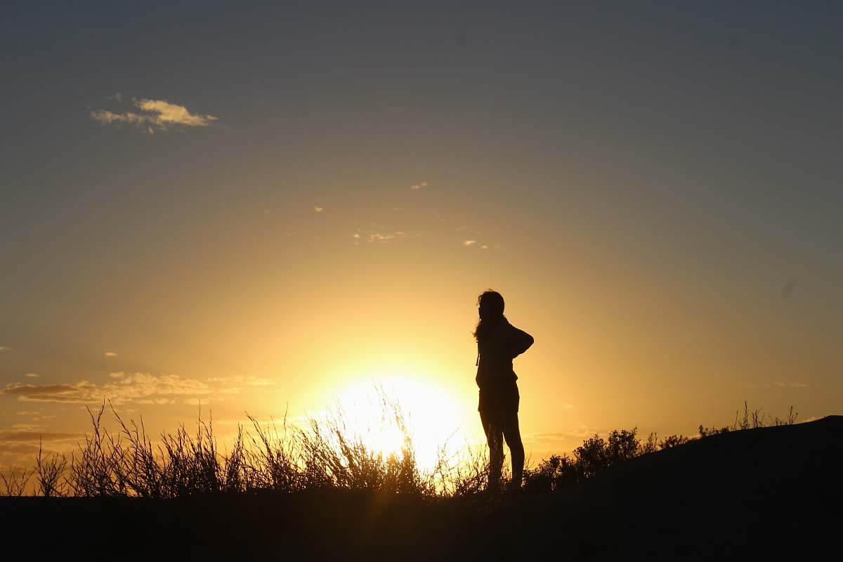 flare silhouette of person standing on grass light