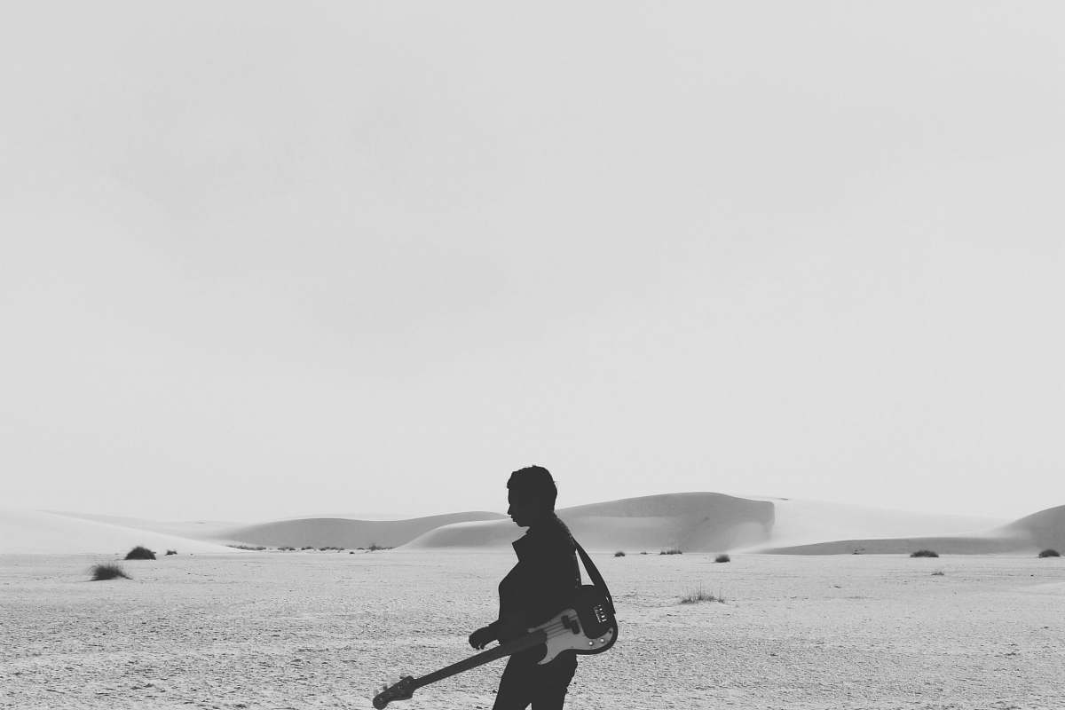 black-and-white silhouette of person with guitar guitar