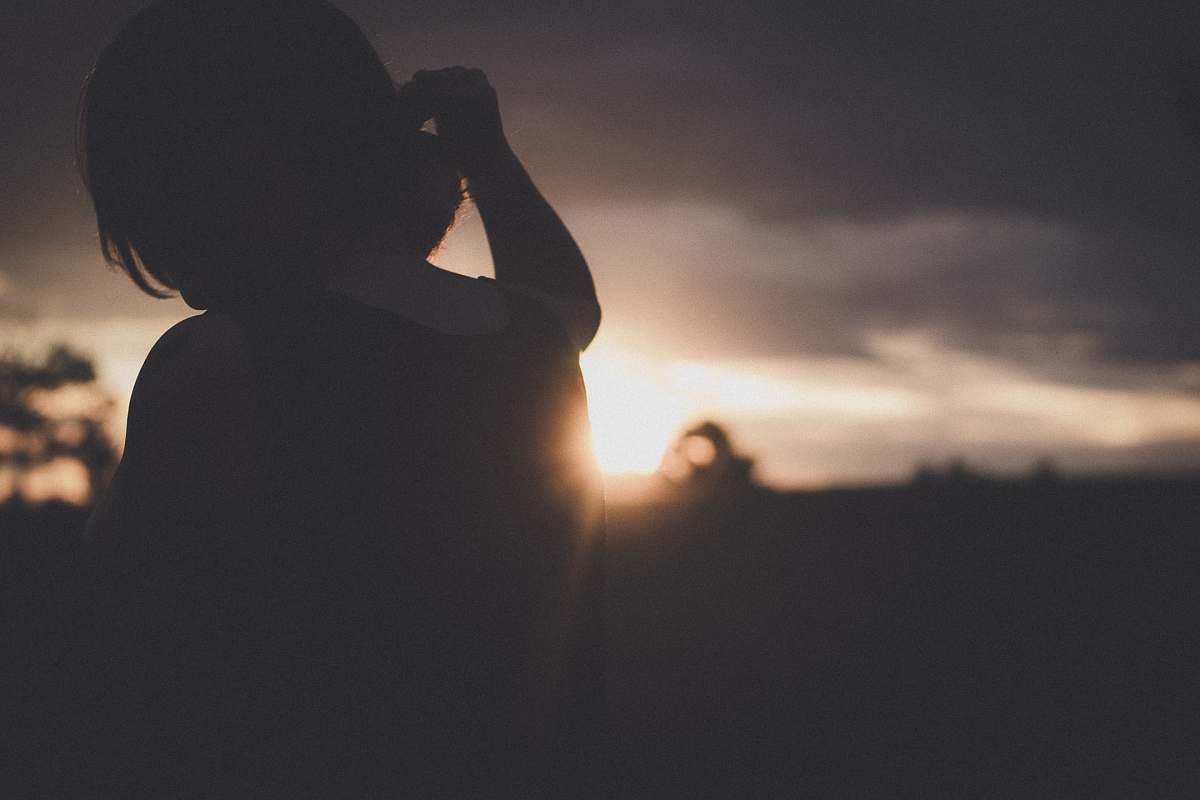 human silhouette of woman standing beside sidewalk people